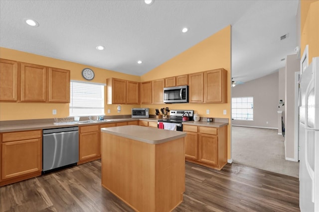 kitchen with lofted ceiling, sink, a center island, stainless steel appliances, and dark wood-type flooring