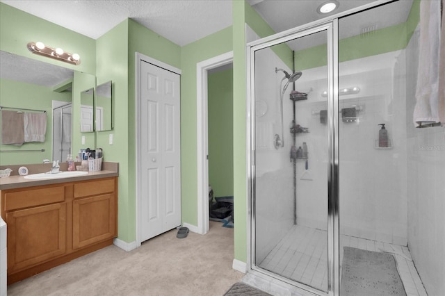 bathroom featuring vanity, a textured ceiling, and walk in shower