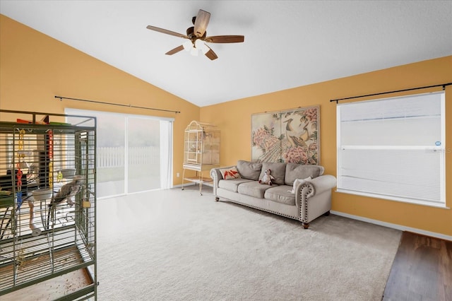 living room with ceiling fan, lofted ceiling, and carpet