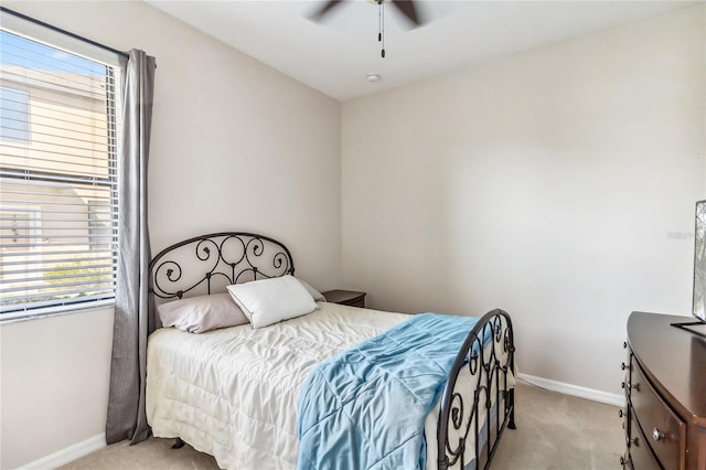 carpeted bedroom featuring multiple windows and ceiling fan