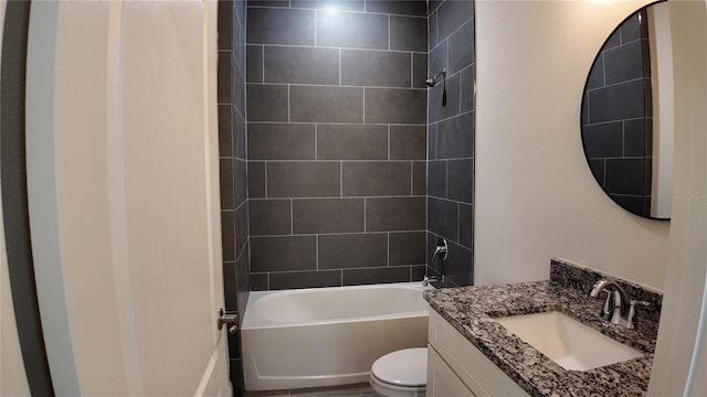 full bathroom featuring vanity, tiled shower / bath combo, and toilet
