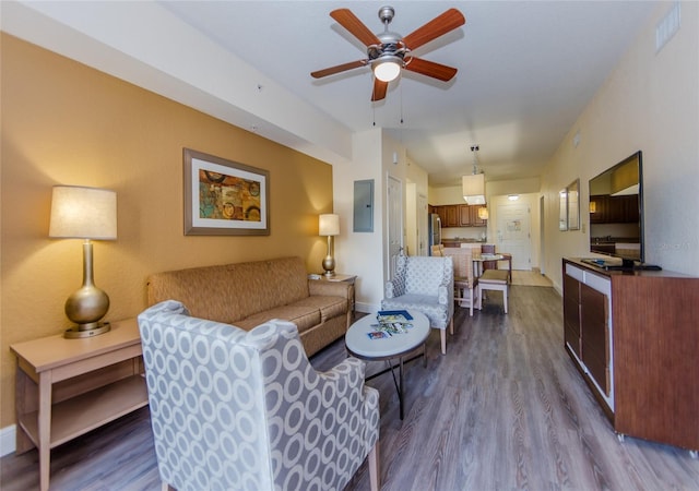 living room with hardwood / wood-style flooring, ceiling fan, and electric panel