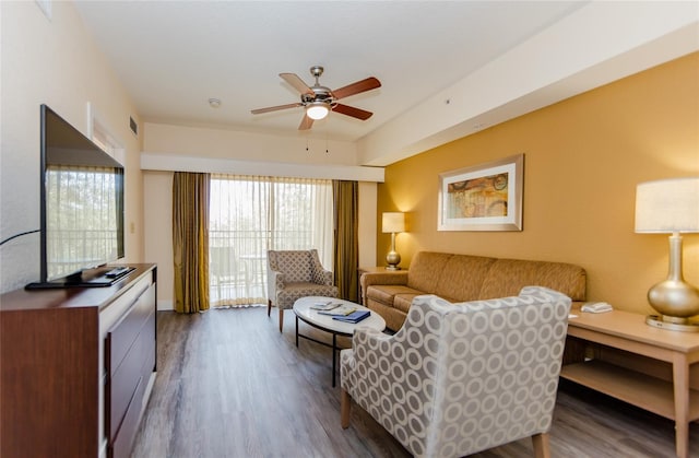 living room with dark wood-type flooring and ceiling fan