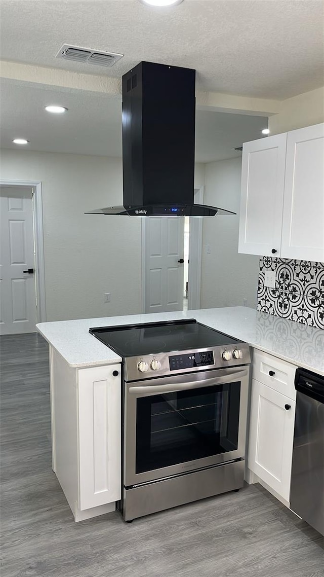 kitchen featuring stainless steel appliances, white cabinets, light wood-type flooring, and range hood