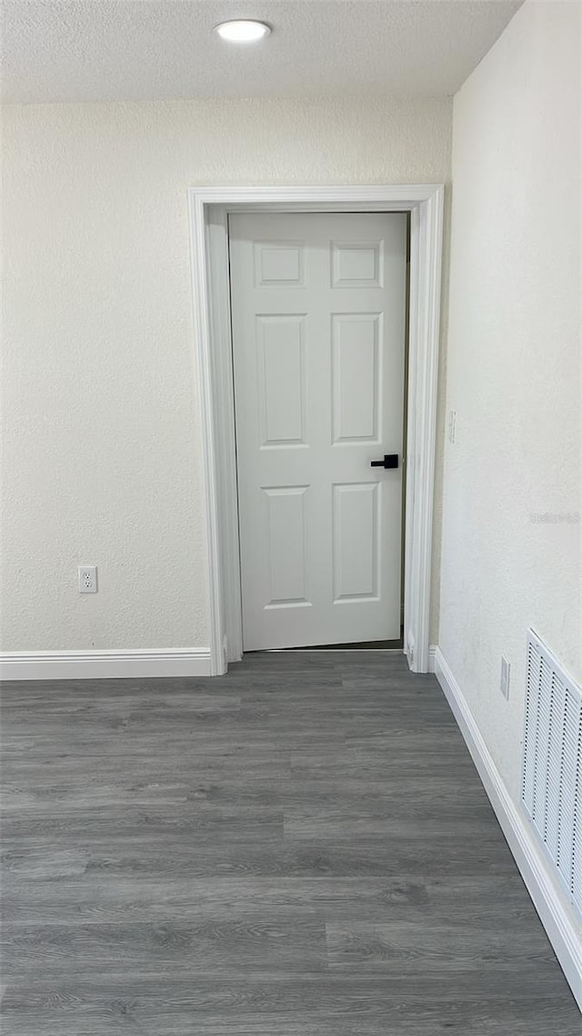 interior space featuring a textured ceiling and dark hardwood / wood-style flooring