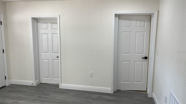 unfurnished bedroom featuring dark hardwood / wood-style flooring