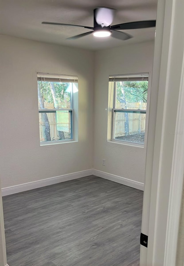 unfurnished room with ceiling fan and dark hardwood / wood-style flooring