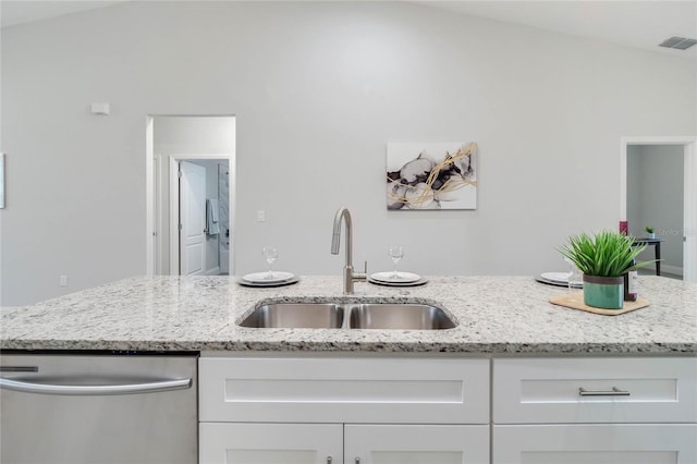 kitchen featuring white cabinetry, stainless steel dishwasher, sink, and light stone counters