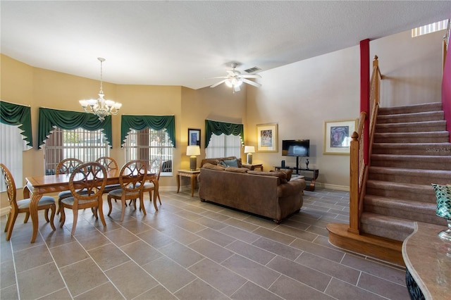 living room featuring ceiling fan with notable chandelier, tile patterned floors, and a textured ceiling