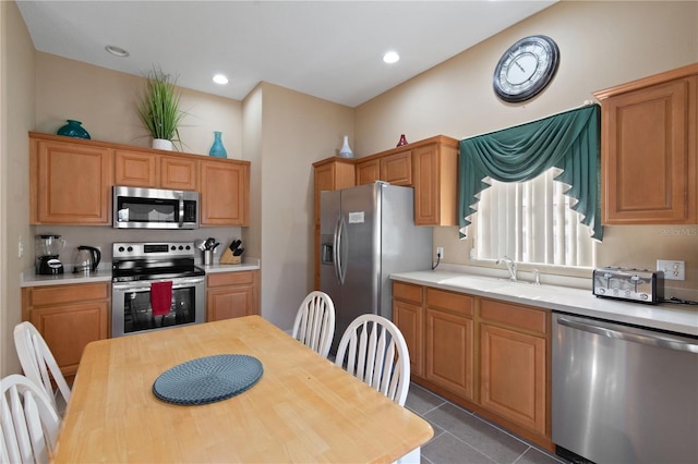 kitchen featuring stainless steel appliances, light tile patterned flooring, and sink