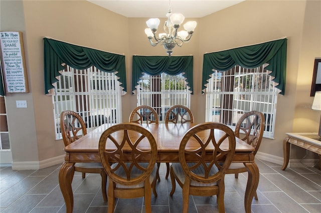 dining area featuring tile patterned floors and an inviting chandelier