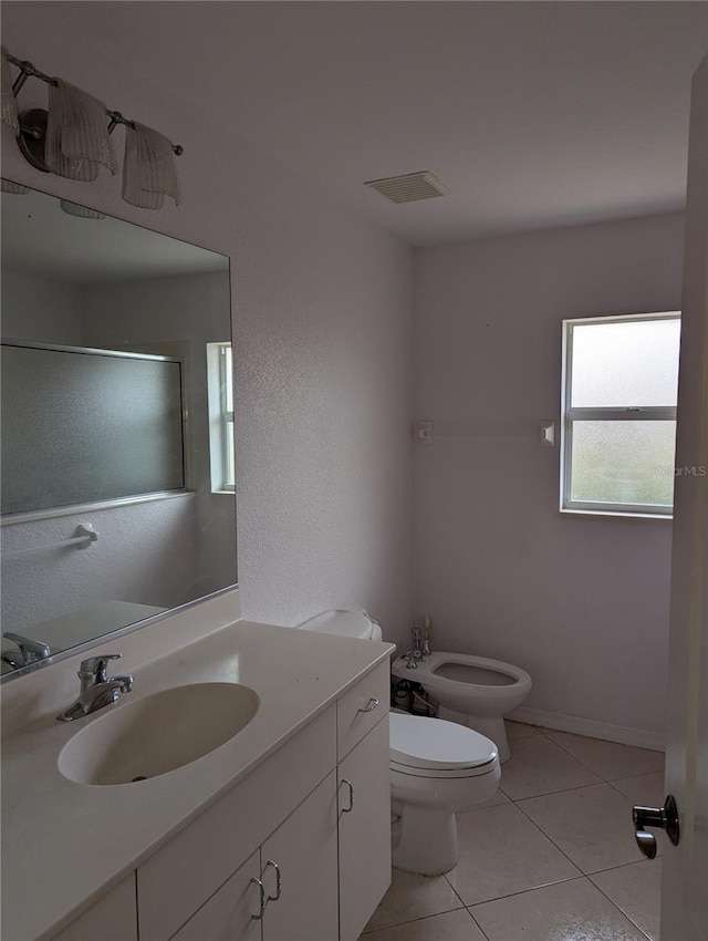 bathroom with a bidet, toilet, tile patterned floors, and vanity