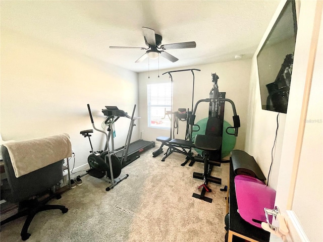 exercise area with ceiling fan, light colored carpet, and a textured ceiling