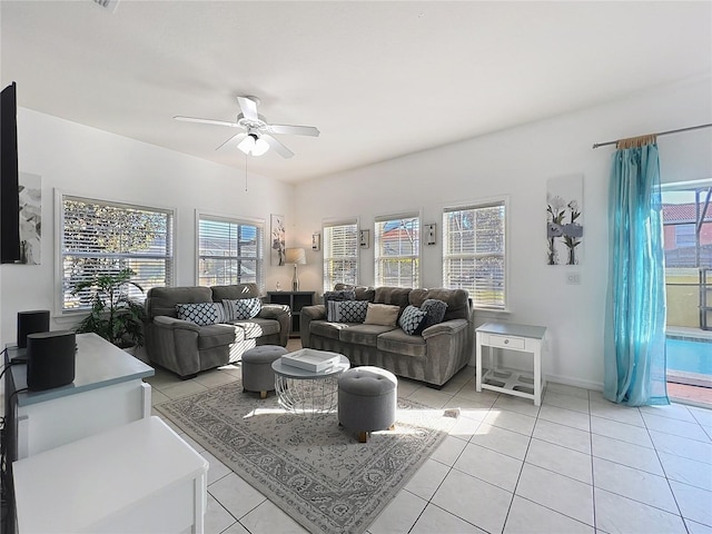 living room with a wealth of natural light, ceiling fan, and light tile patterned flooring