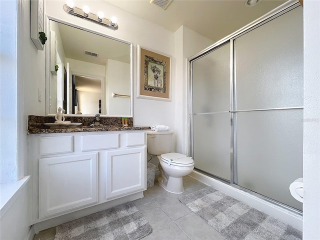 bathroom featuring vanity, toilet, tile patterned floors, and a shower with shower door