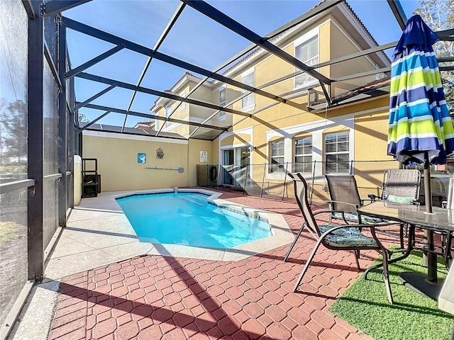 view of pool featuring glass enclosure and a patio area