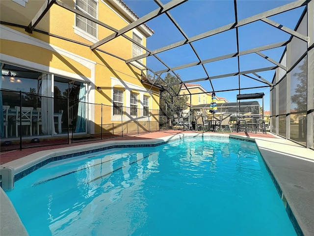 view of pool with a patio and glass enclosure