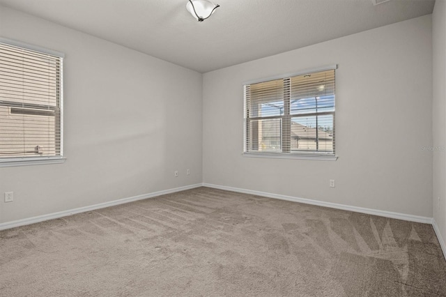 empty room featuring baseboards and carpet