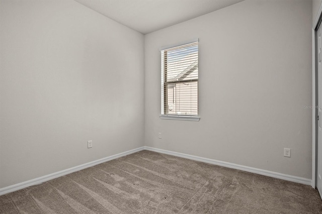 empty room with baseboards and carpet