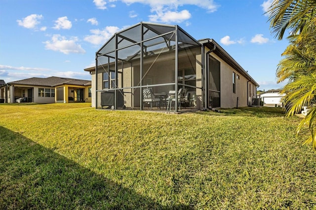 back of house with glass enclosure and a lawn