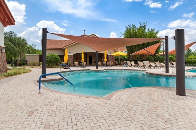 community pool with a patio and fence