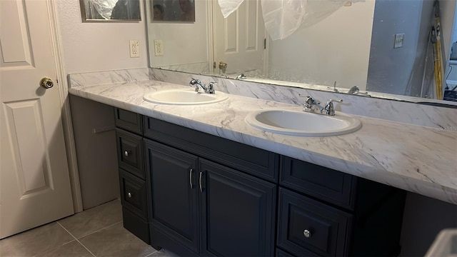 bathroom featuring double vanity, a sink, and tile patterned floors