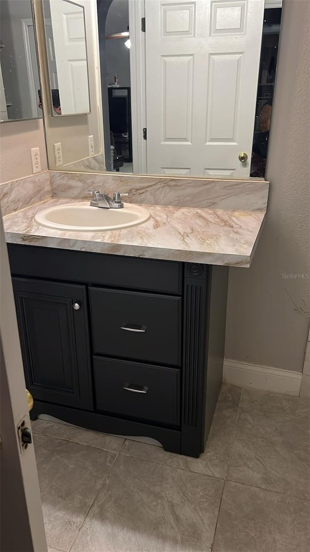 bathroom featuring tile patterned flooring, baseboards, and vanity