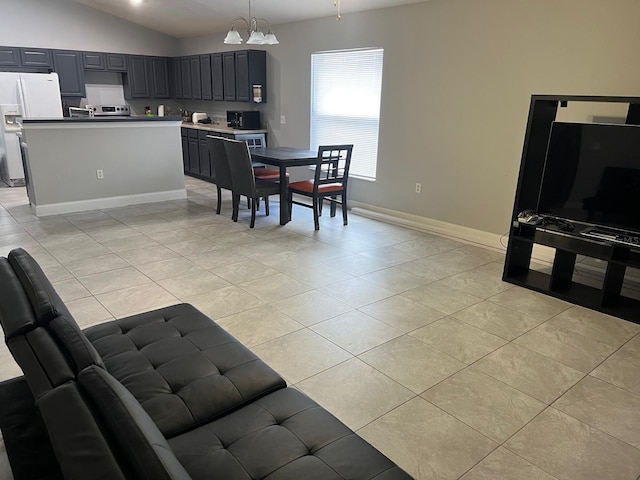 kitchen featuring hanging light fixtures, white refrigerator with ice dispenser, light countertops, and open floor plan