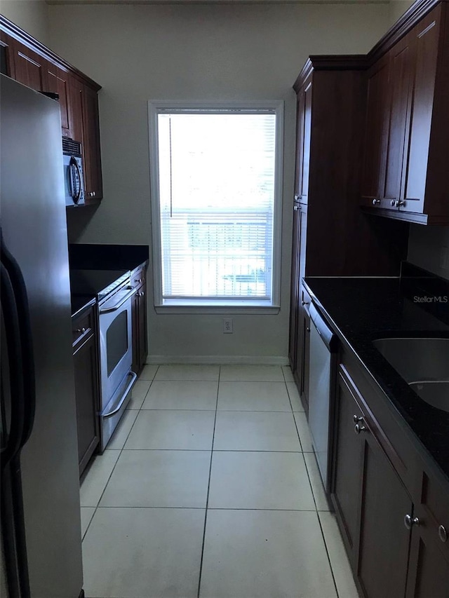 kitchen with sink, light tile patterned floors, and stainless steel appliances