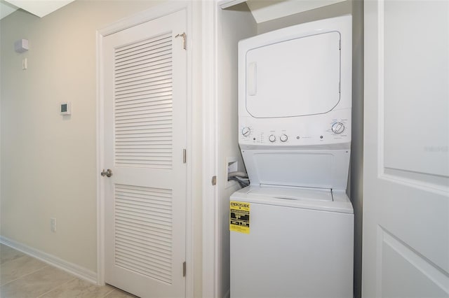 clothes washing area with stacked washer and dryer and light tile patterned floors