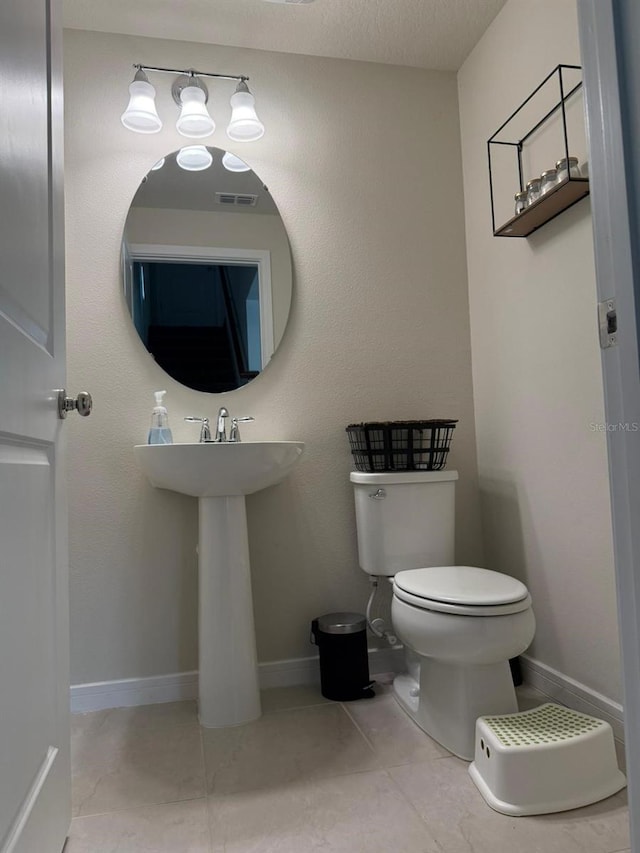 bathroom with tile patterned floors, a textured ceiling, and toilet