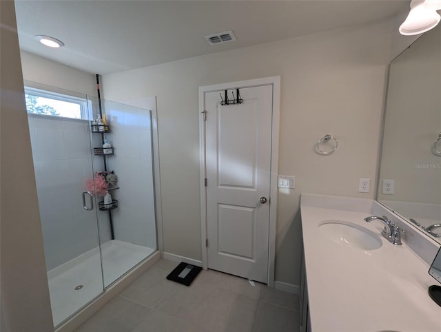 bathroom featuring a shower with door and vanity