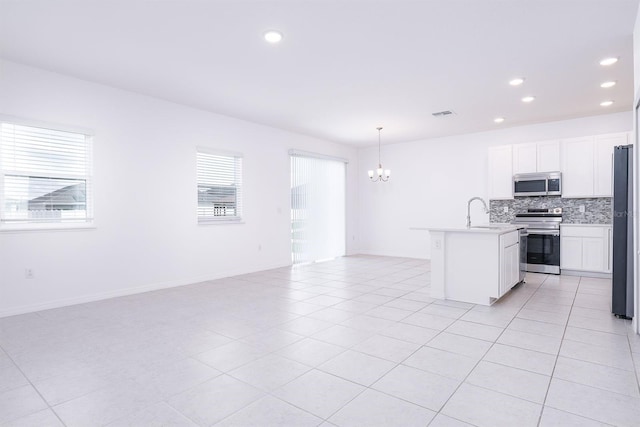 kitchen featuring stainless steel appliances, white cabinets, decorative backsplash, and decorative light fixtures