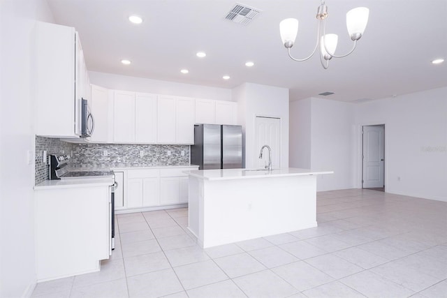 kitchen with appliances with stainless steel finishes, decorative light fixtures, a center island with sink, and white cabinets