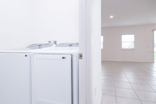 clothes washing area featuring washer and dryer and light tile patterned flooring