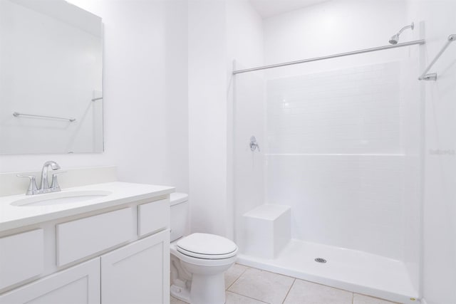 bathroom featuring tile patterned flooring, vanity, a shower, and toilet