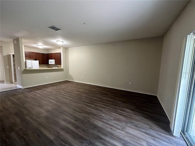 unfurnished living room with dark wood-type flooring