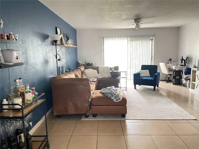 living room with ceiling fan, a textured ceiling, and light tile patterned floors