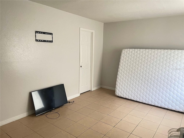 empty room with light tile patterned floors and a textured ceiling