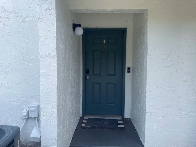 entrance to property featuring cooling unit