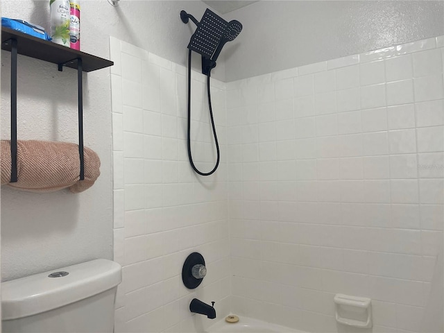 bathroom with tiled shower / bath and toilet