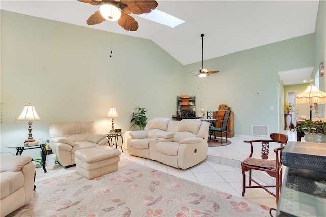 tiled living room featuring ceiling fan and vaulted ceiling with skylight