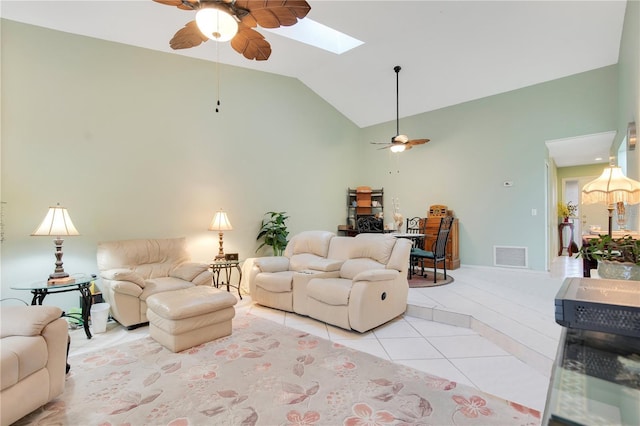 tiled living room with ceiling fan and vaulted ceiling with skylight