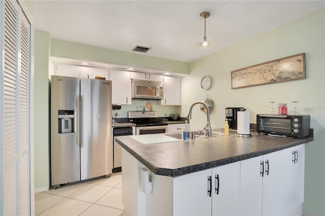 kitchen featuring sink, white cabinetry, hanging light fixtures, light tile patterned floors, and appliances with stainless steel finishes