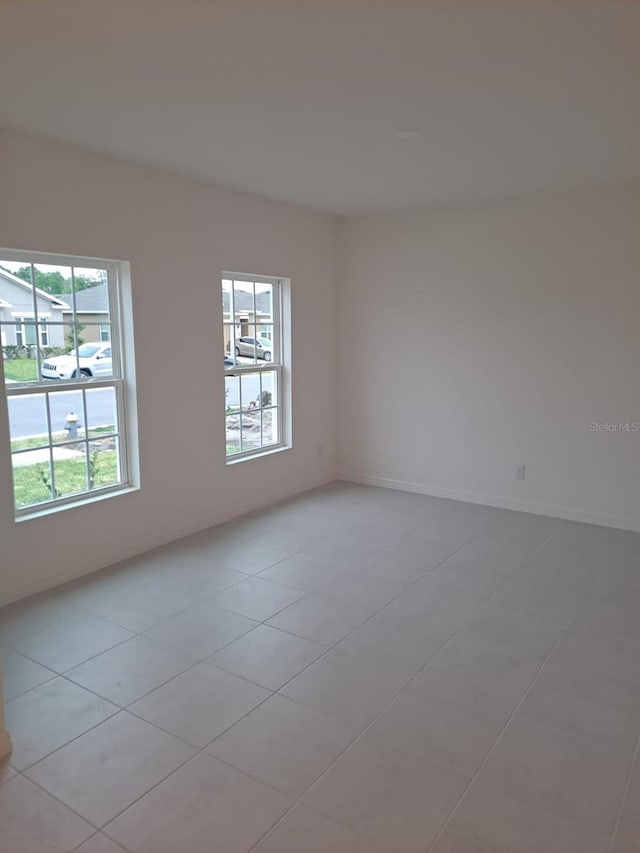 empty room featuring plenty of natural light and light tile patterned floors