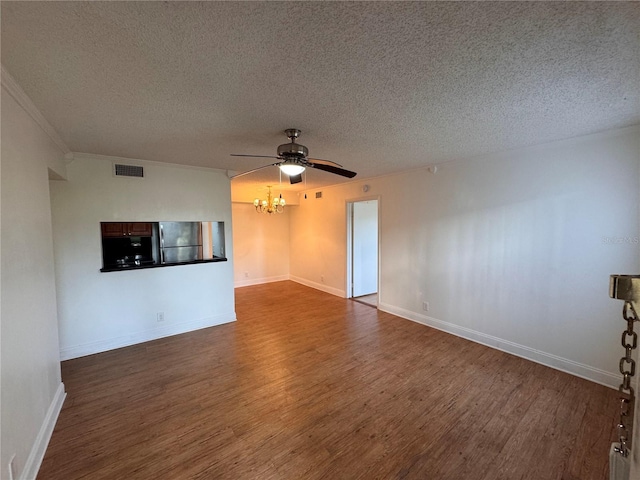 empty room featuring crown molding, ceiling fan with notable chandelier, dark wood-type flooring, and a textured ceiling