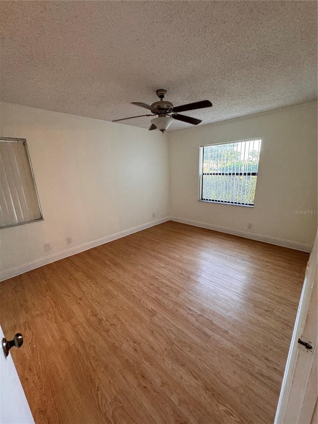 spare room with ceiling fan, a textured ceiling, and light wood-type flooring