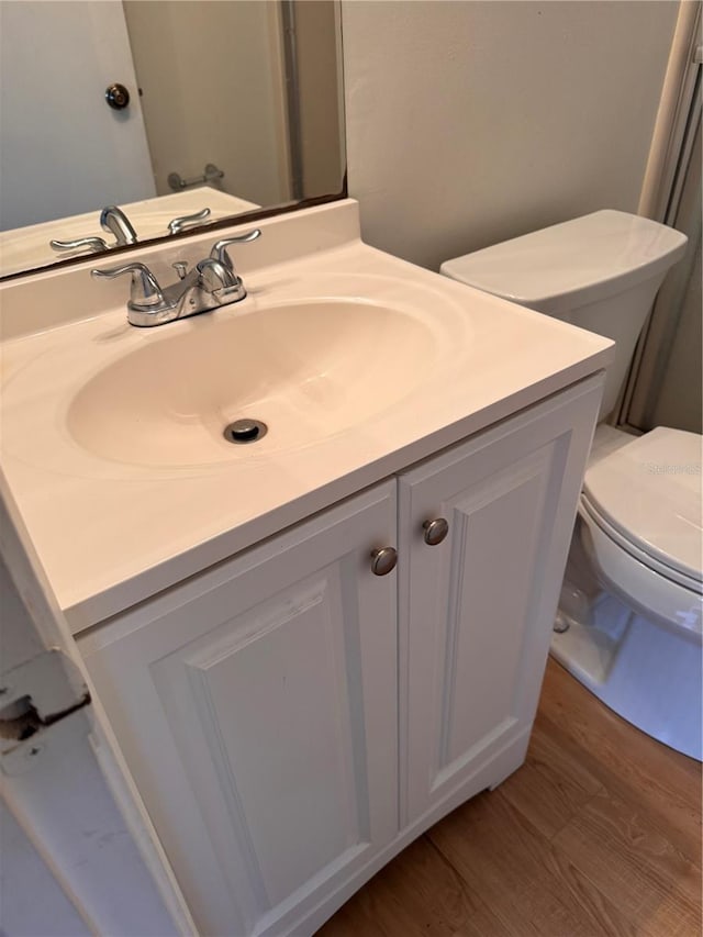 bathroom featuring vanity, hardwood / wood-style floors, and toilet