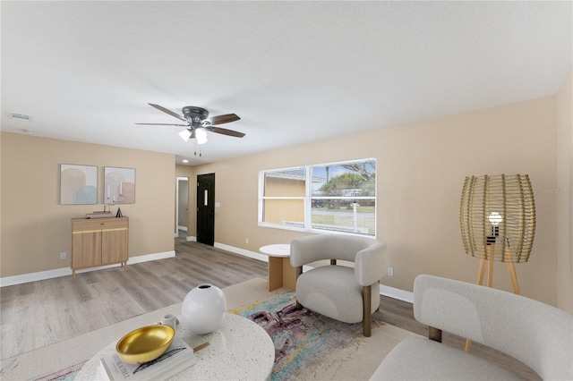 living area featuring ceiling fan and light hardwood / wood-style flooring