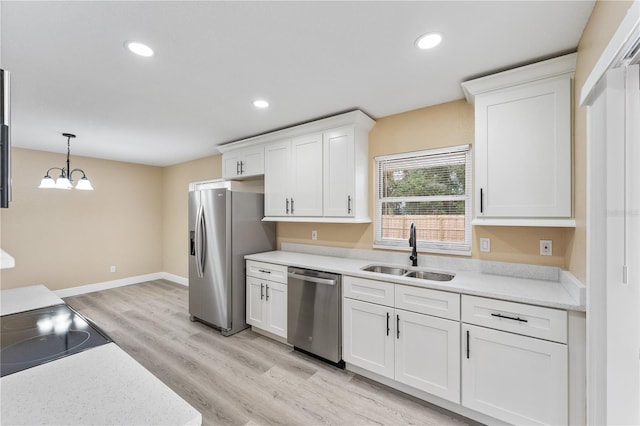 kitchen with sink, decorative light fixtures, stainless steel appliances, light hardwood / wood-style floors, and white cabinets